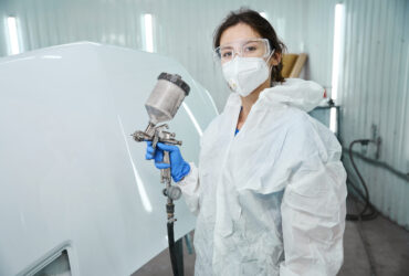 Woman at work uses protective overalls, goggles and a respirator Woman at work uses protective overalls, goggles and a respirator, she is in a paint shop